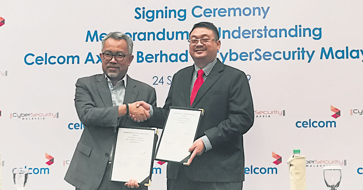 ▲莫哈末依丹（左）及阿米鲁丁签署合作备忘录，致力强化网络数码安全。