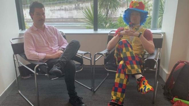 汤普森（左）请一名专业小丑，陪他参加解雇说明会。