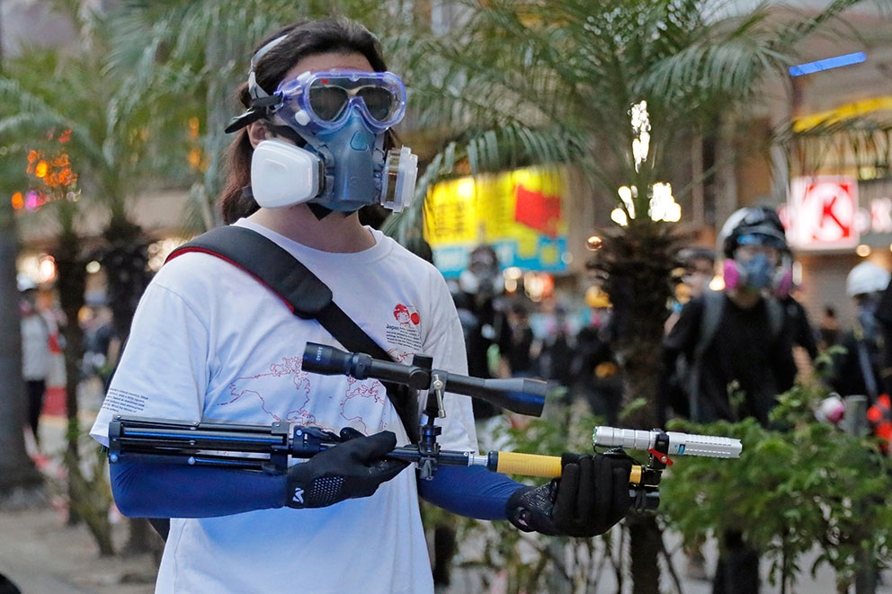 一名示威者带着面罩，手上拿着一把激光镭射枪。（美联社）