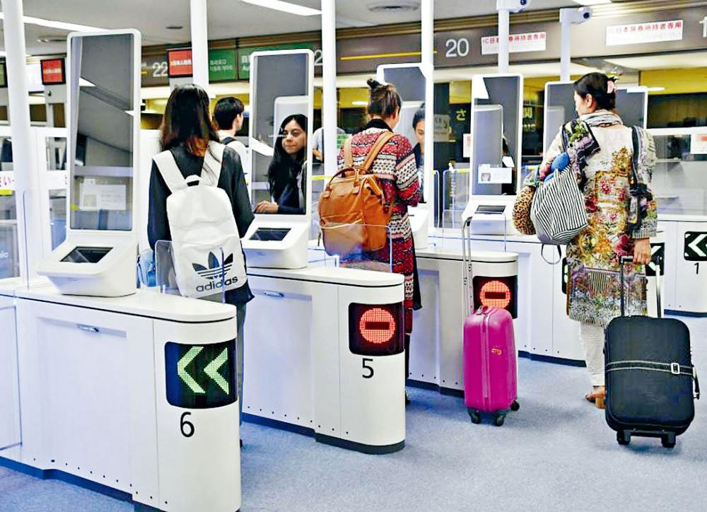旅客在成田机场用人脸识别自动门入境。