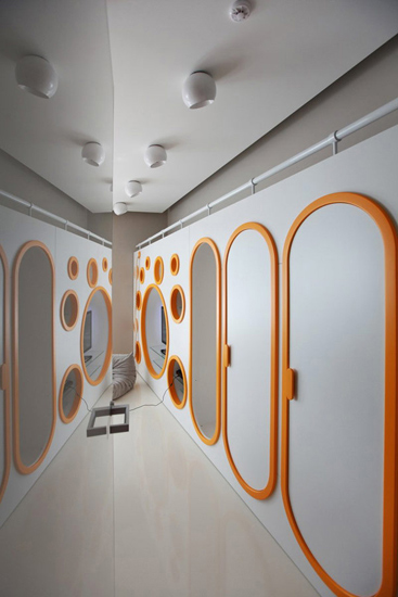 镜面墙体扩大空间 镜面墙体和地板显得十分光滑，从视觉上扩大了空间感，让狭窄的走廊过道显得宽敞整洁。橙色的边框让这个收纳空间显得十分抢眼和有立体感。