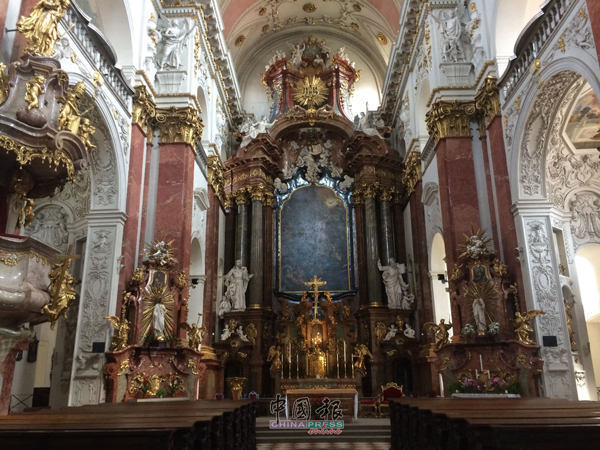 这是一座位于布拉格的天主教教堂，内部装潢金碧辉煌，似乎述说着一段光辉的过去。