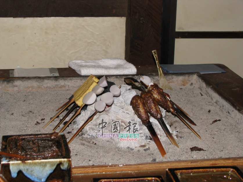 传统烤麻糬店内的火炭烤得火火红红的，一踏入就有厚厚的暖意。