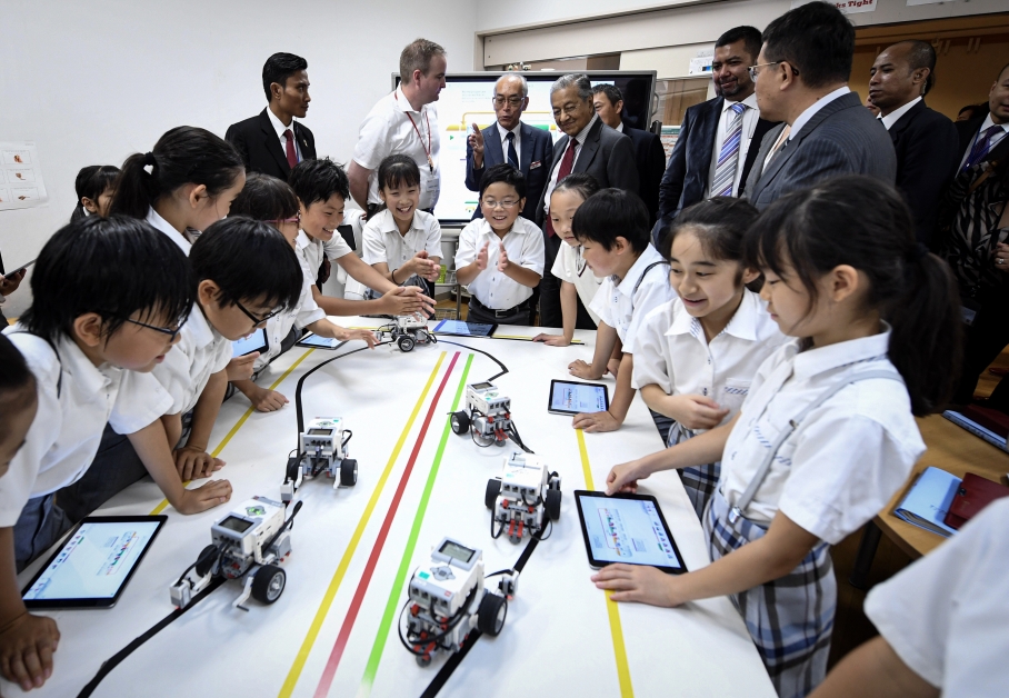 马哈迪观摩立命馆小学的学生如何学习以平板电脑操控小型机械车。