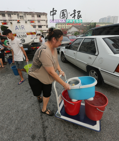 一些居民出动手推车装水，以供家人使用。