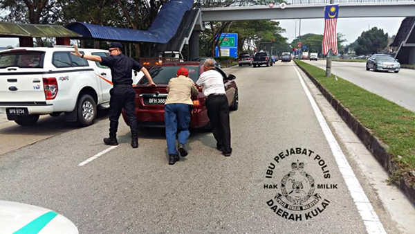 两名华裔公众上前协助警员，一起将坏在路中央的轿车推到路旁，以让交通恢复顺畅。