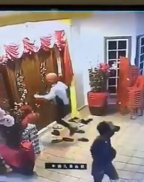 其中一名戴红色头盔的匪徒试图用脚飞踢，以撞开大门。