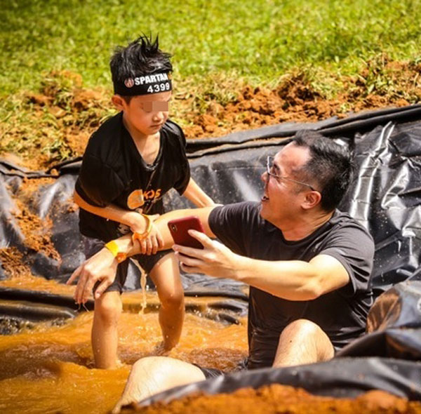 赵元同跌坐在泥水中，儿子奋力将老爸拉起。
