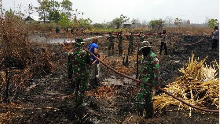 在中加里曼丹省帕朗卡拉亚，军人在林火肆虐的地区协助灭火工作。