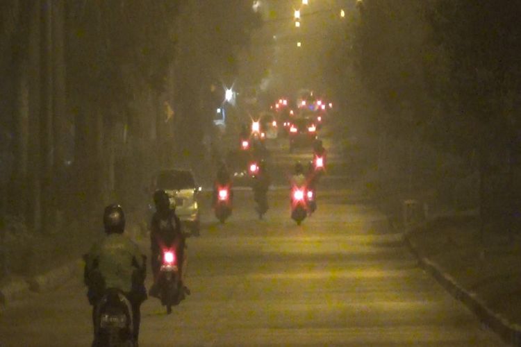 中加里曼丹省帕朗卡拉亚被浓浓烟霾笼罩，摩哆骑士缓慢行驶。