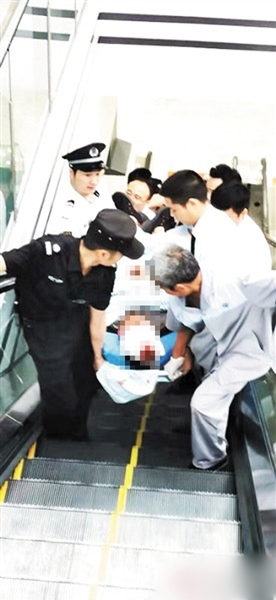 医疗人员把跌倒受伤的男子抬走，准备送院治疗。