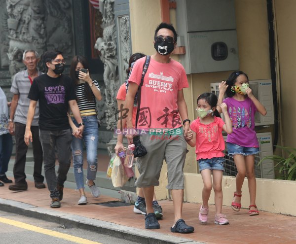 不少到鸡场街的游客，自备口罩防霾害。