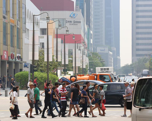 新加坡市区一些行人开始戴口罩，但多数人如常生活。 