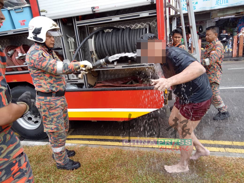 消拯员将男子救上后，用水为男子洗清一番。