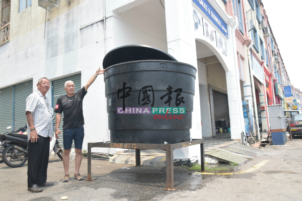 谭锡尧（右）及冯荣月指着，逾百户住户共用一个大水槽。
