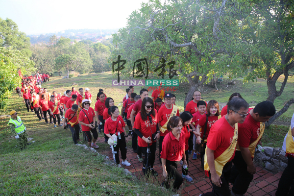 参与“三山九九．重阳登高”活动的公众穿上红衣，随着队伍登上三宝山，形成红色人龙。