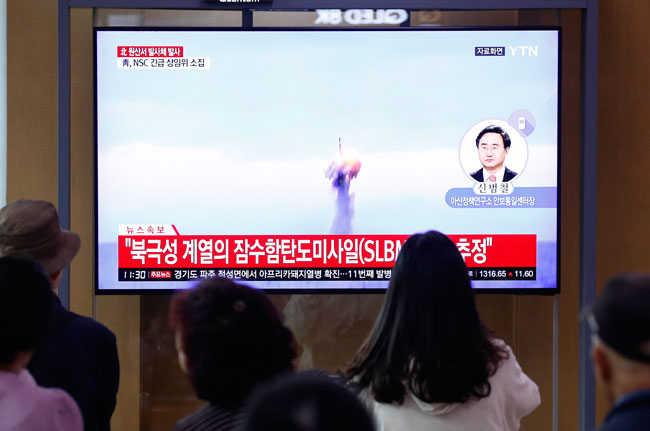 在韩国首尔地铁站，民众在观看朝鲜射弹的即时报导。（欧新社）
