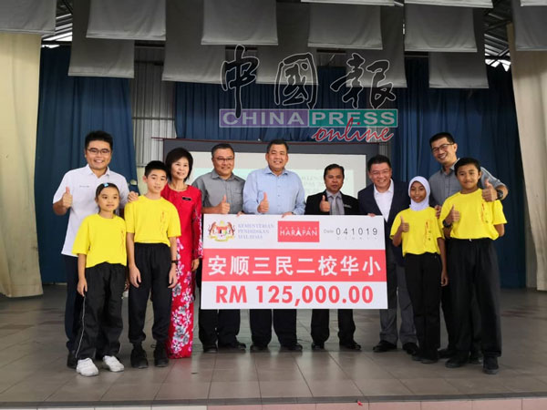 倪可敏（右4）移交12万5000令吉模拟支票，给三民华小二校董事长王立光（左6）。