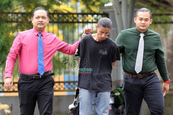 莫哈末哈欣（中）被警方带往法庭面控。