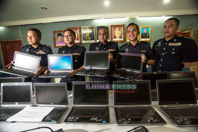 诺阿兹米（左2）在记者会上展示所起获的笔记型电脑。左起为副警区主任再益。