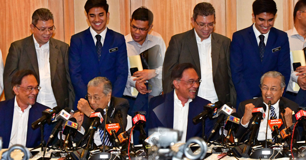 马哈迪（坐者左2）回答媒体提问时打趣地摆出握拳姿势，作状要和安华“打架”。