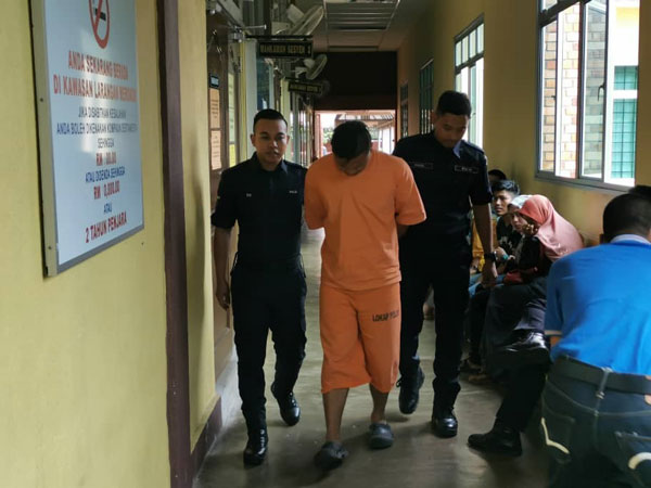 被告莫哈末希拉兹（中）被控后，遭警方押离法庭。