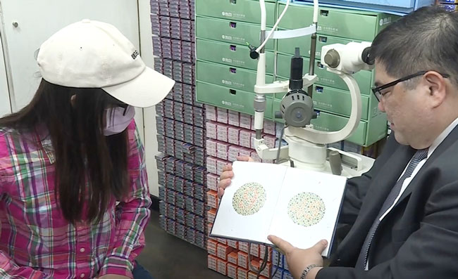 刘姓少女（左）在接受眼睛色盲检验，右为台湾大仁科大眼科副教授洪启庭。