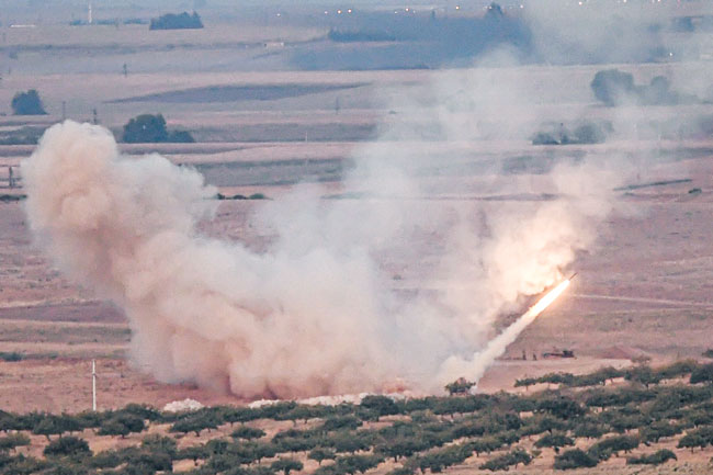 库尔德族战士为守住叙利亚边界要城拉斯埃恩，周二与土耳其支持的部队爆发激战，图为土军周二向拉斯埃恩发射导弹。（法新社）
