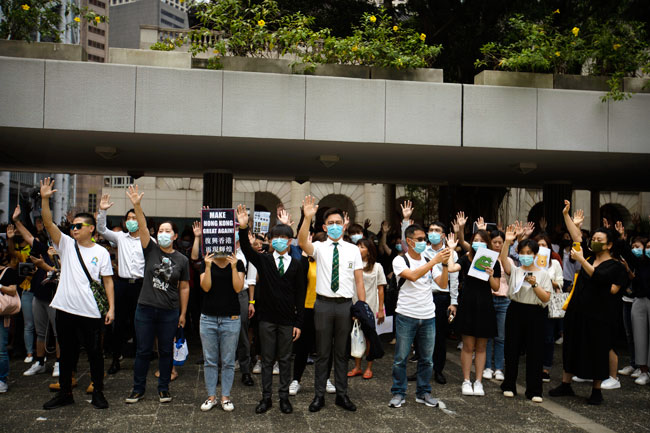 示威者周五在香港中区戴着口罩举办“快闪”行动。