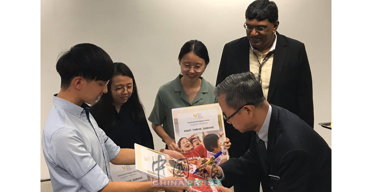李文材（前排右）为马来西亚国家癌症协会推出的癌症者教育书籍签名。