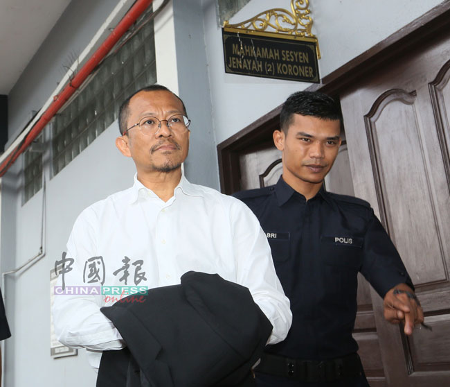 被告马兹兰（左）由庭警押离法庭进入拘留室。