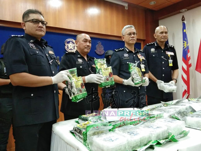 哈山努丁（右2）与肃毒组警官，发布茶包运毒详情。