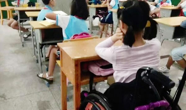 女童尽管已返校上课，但需要轮椅辅助。