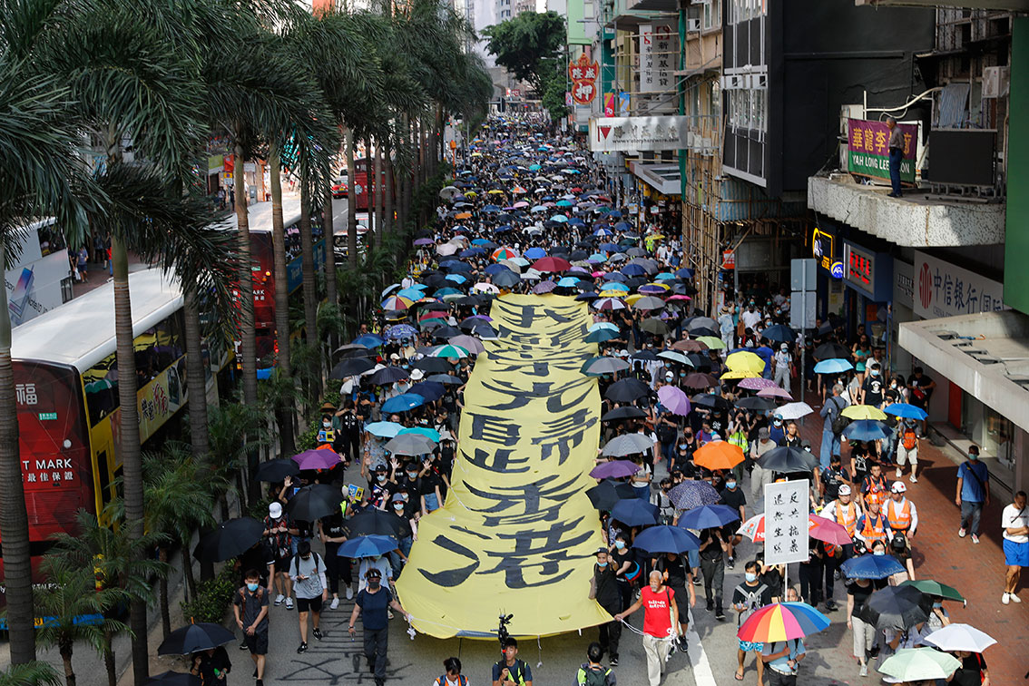 队头示威者拉起黄底黑字写有“愿荣光归香港”巨型直幡。