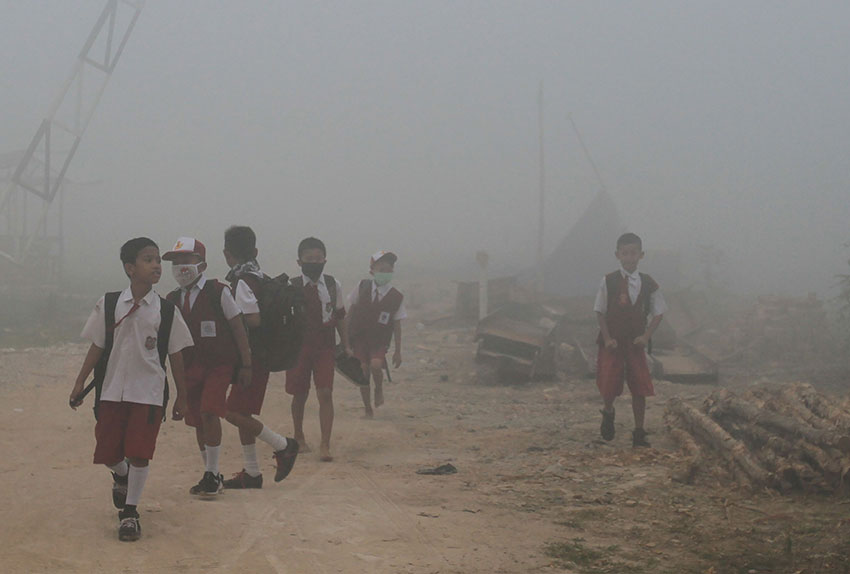 巨港周一烟霾笼罩，学生们戴上口罩。（法新社）