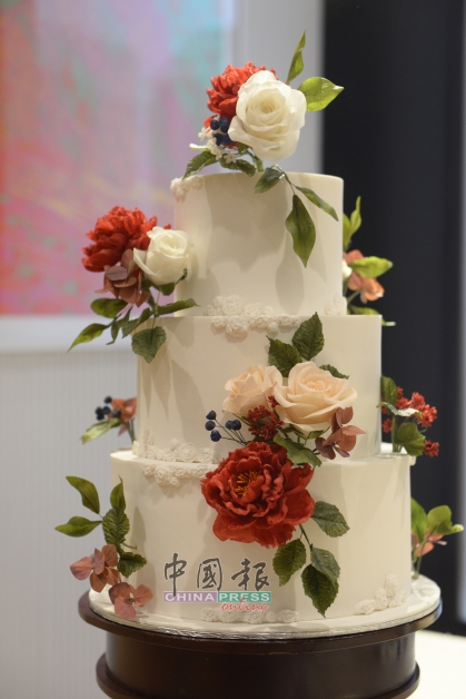 陈美玲制作的翻糖花，花瓣薄如蝉翼，几可乱真。这款婚礼蛋糕饰以甜蜜浪漫的翻糖花，取名为“翻糖花婚礼蛋糕”。