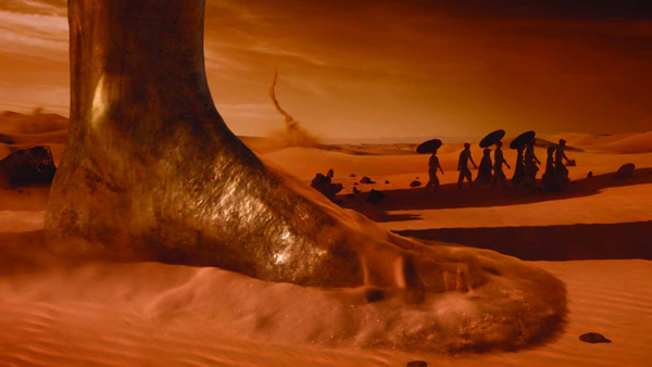“Flowing Flame”中的沙漠场景，行走的信徒在棚内拍摄，以3D遮罩绘景技术（Matte Painting），打造出具金属质地的巨人，以及漫天黄沙的荒漠效果。