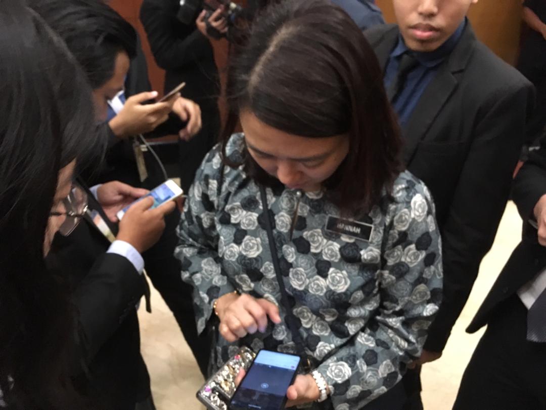 闻讯而至的妇女、家庭与社会发展部副部长杨巧双在国会诊所外等候最新消息时，向媒体借电话了解事发经过。