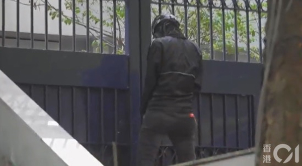 一名黑衣人在尖沙咀警局门外撤尿。