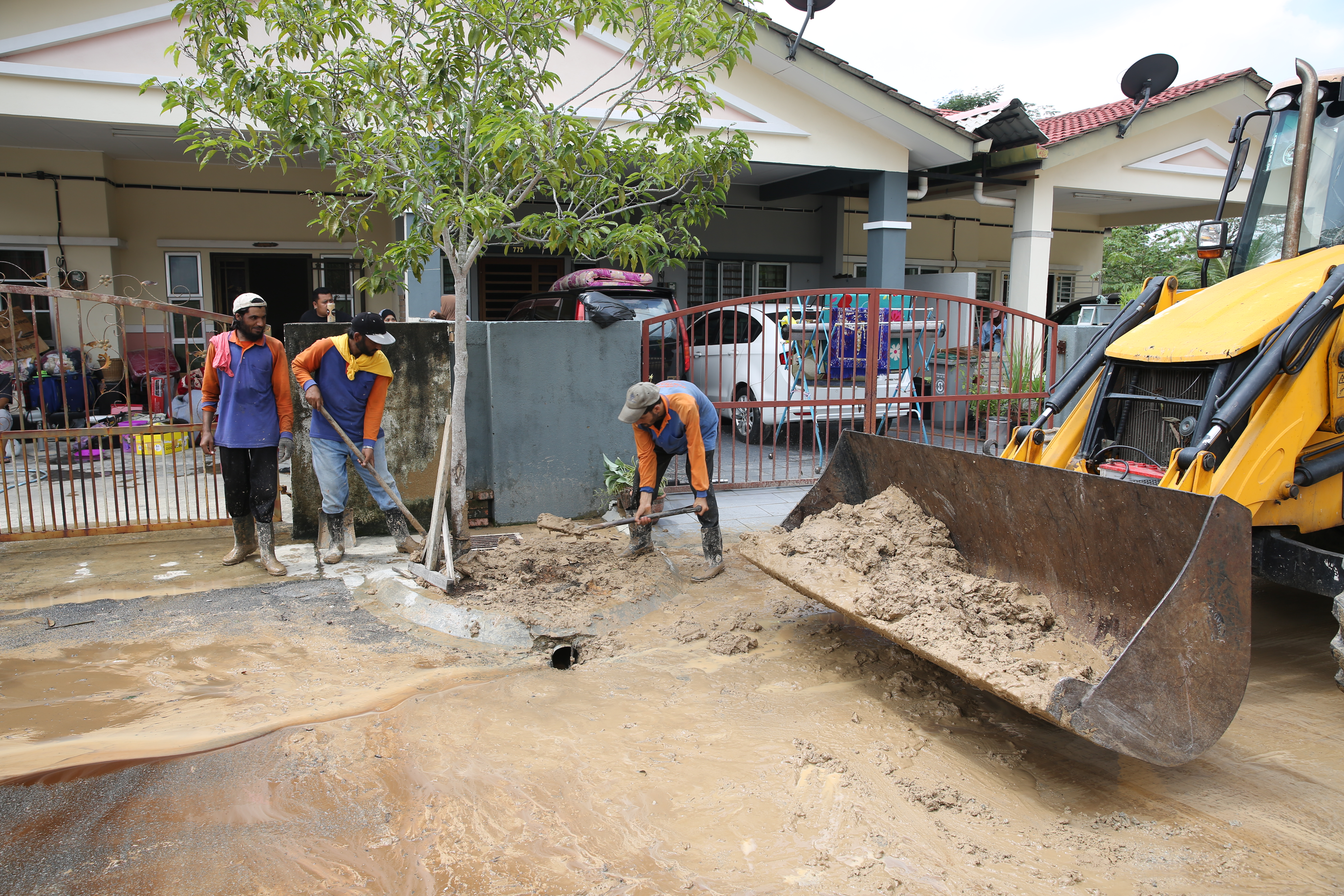 水灾后满地泥浆及垃圾，市议会出动紧急行动小组进行清理工作。