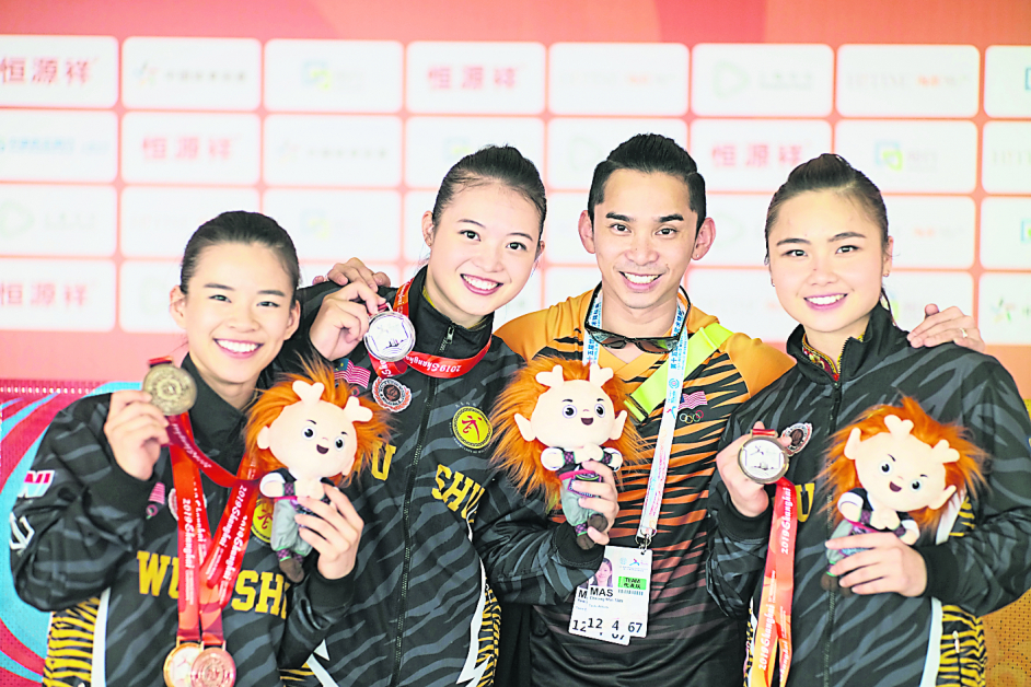 教练林佑辉（右2）与队员陈昌敏（左起）、潘依嫣和罗莹婷庆祝女子对练收获银牌。（教练林佑辉提供）