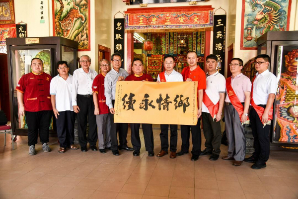 三忠宫主席拿督威拉陈江荣（左6起）赠送墨宝给周鲁闽。