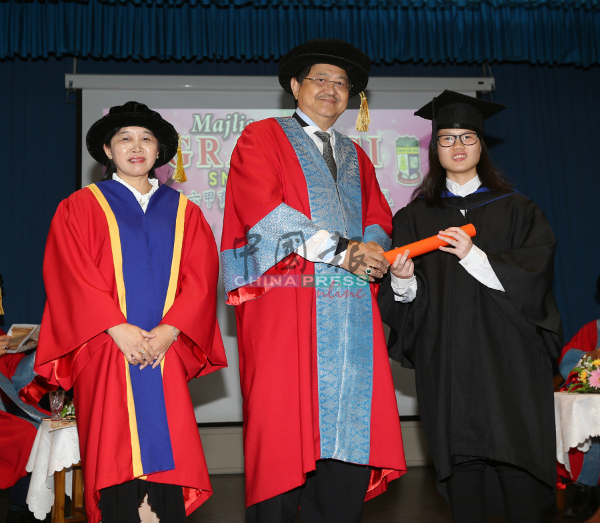 林朝盛（中）与郭贞莹（左）颁发证书给文科班毕业生。