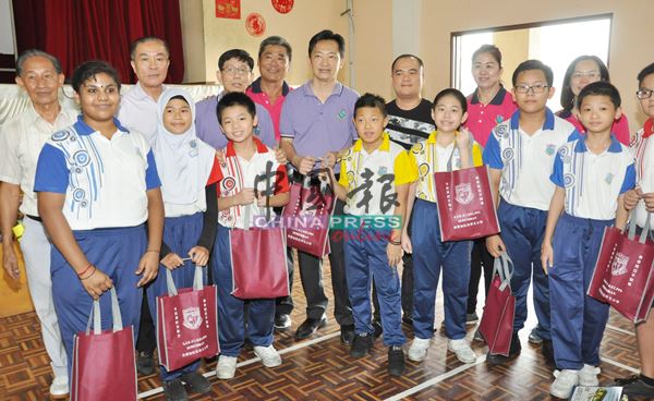 谢琪清（后排左5）派发儿童节恩物予加小学生。后排左起梁光灿、黄国强、刘双赈及余养金。