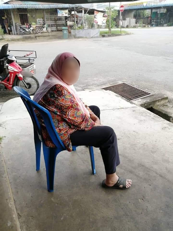 当时，老妇在杂货店前坐着，迟迟等不到孩子来接回家。（取自Penang Kini）