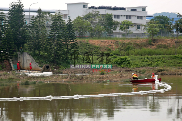 武吉纳那废料处理中心特别拯救部队人员，划船进入受污染的集水池进行处理工作，包括阻挡泡沫污水流往河水。