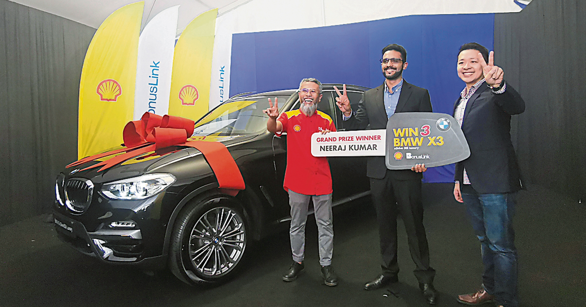 沙艾然胡扎尼（左）及黄宏玮（右）将模拟钥匙颁给“WIN 3 BMW X3”有奖竞赛第一回合大奖得主尼拉古玛。