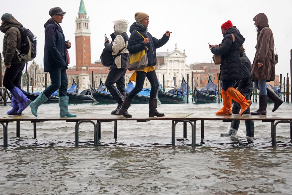 威尼斯12日早的水位达127公分，民众被迫走在架高的台上。（欧新社）