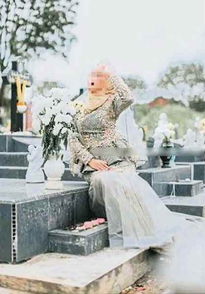 女子不忌讳坐在墓碑前摆“甫士”拍照。（图取自Siakap Keli网站）