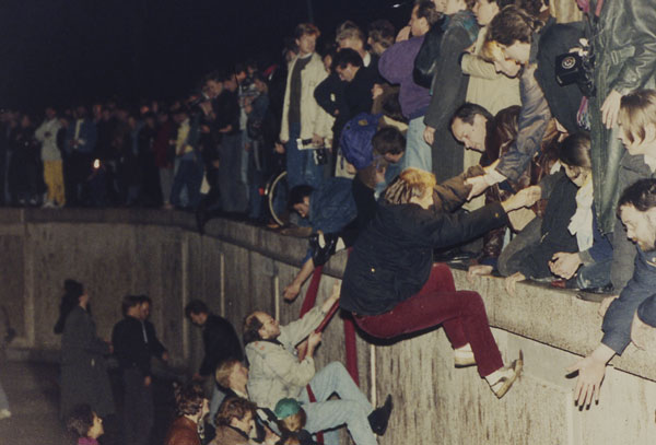1989年11月10日，西德民众向东德人民伸出援手，帮助他们越过围墙。